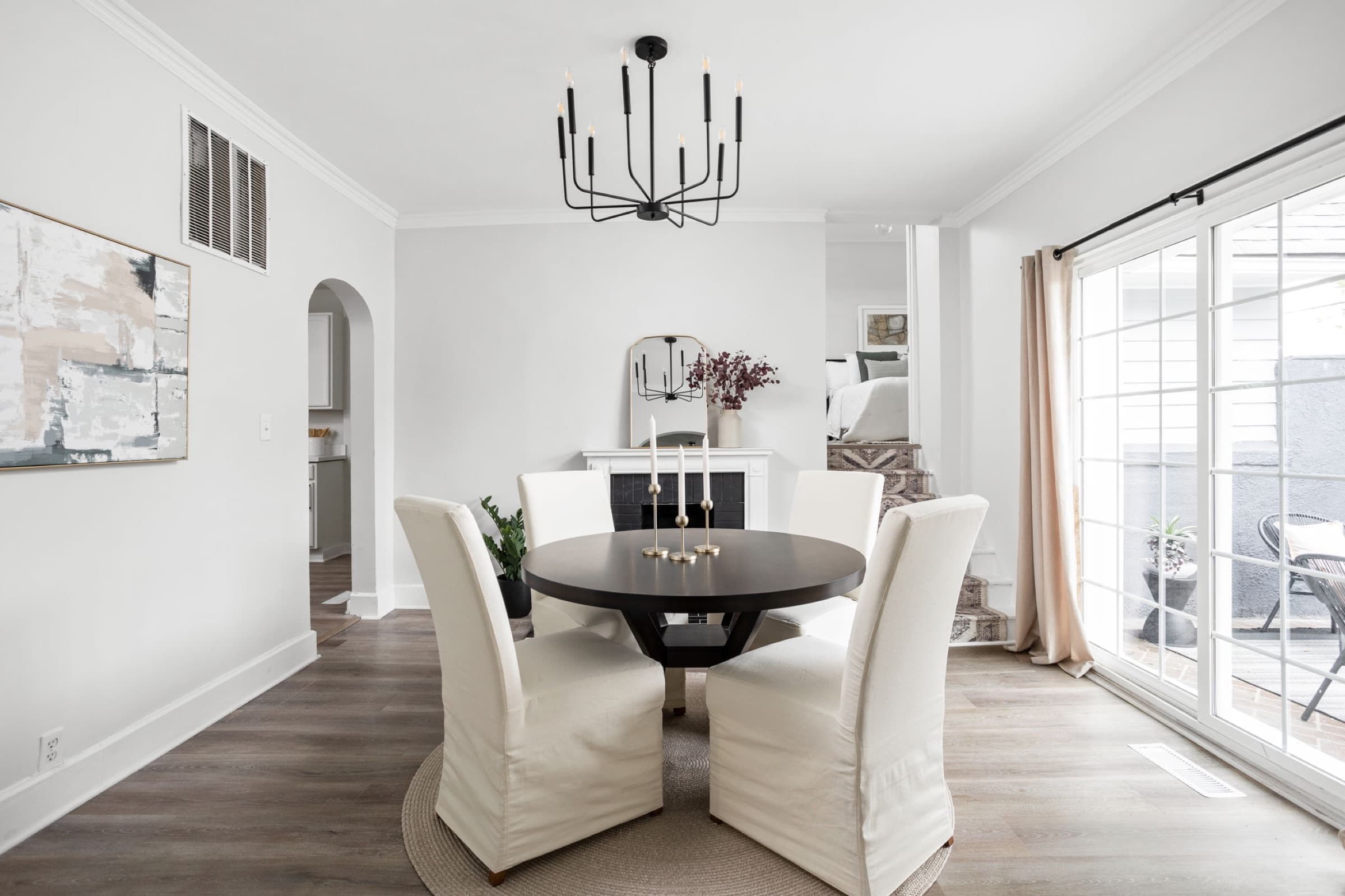 Staged dining room in a Meridian-Kessler listing with slipcovered chairs and a modern chandelier