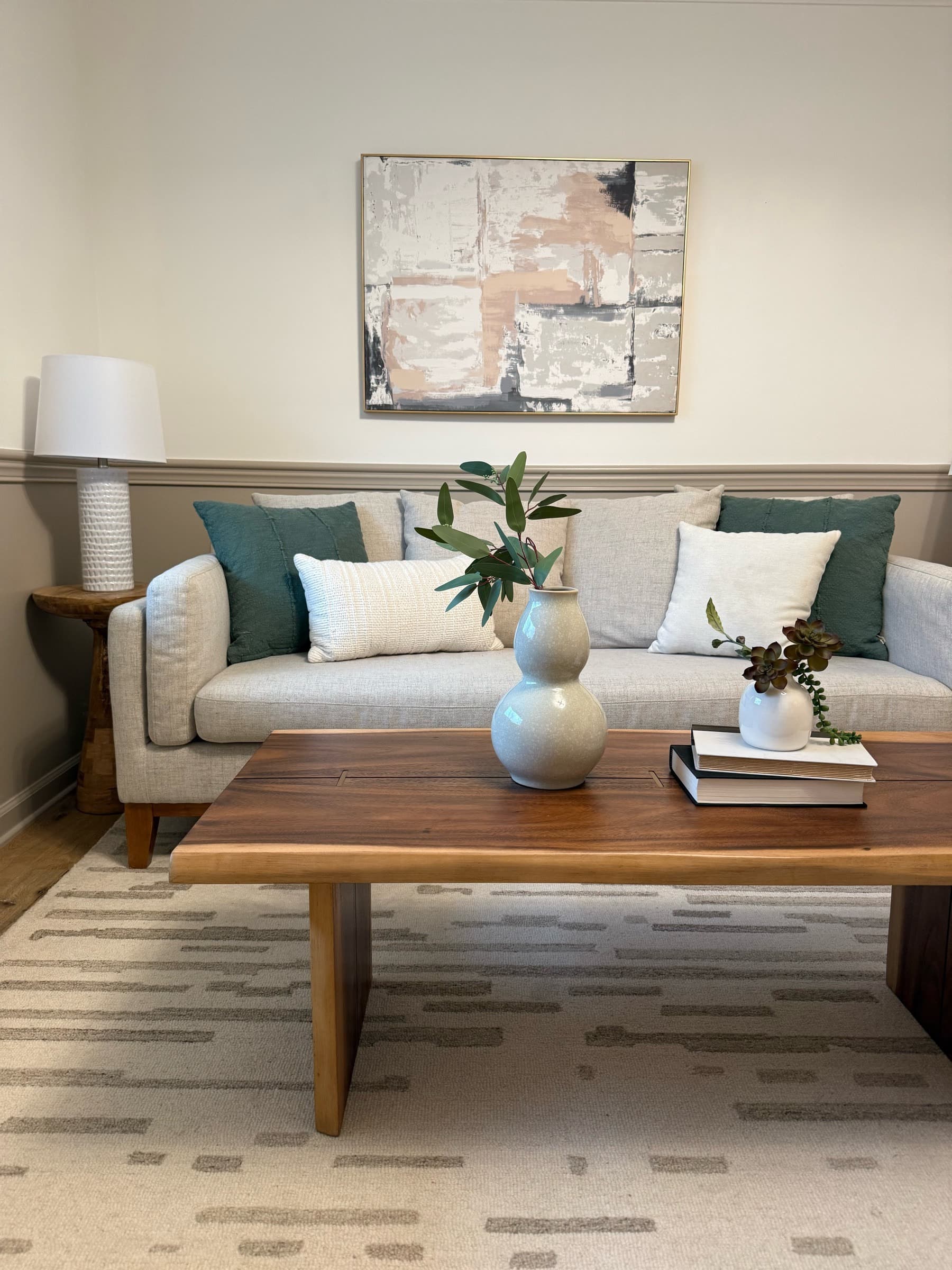 Occupied living room elevated with styled pillows, layered decor, and a walnut coffee table